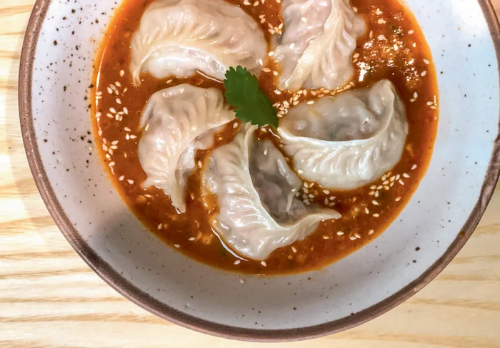 Momos in a spicy soupy sauce (Jhol Achaar)are the new rage in New Delhi
